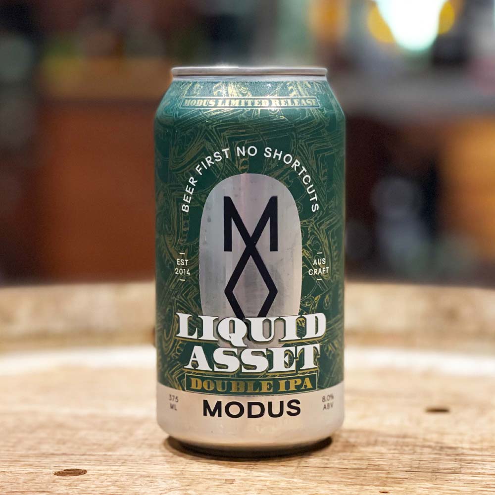 Green beer can with 'Liquid Asset' branding on a wooden surface